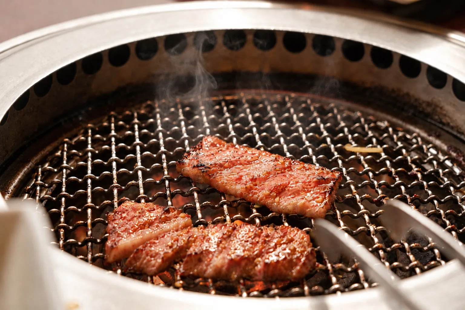 炭火の網で焼くお肉のイメージ写真